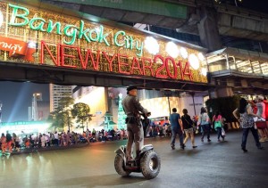 A Thai police officer patrols as people start to gather on a street outside the Central World shopping mall to celebrate the New Year in Bangkok, Thailand, Tuesday, Dec. 31, 2013. (AP Photo/Apichart Weerawong) 