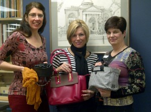 Wanda Bell, Michelle Goetheyn and Tania Sharpe hold purses in launch of fundraiser. Photo Chatham-Kent Public Library