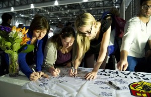 University of Calgary students and staff sign condolences on a University of Calgary banner during a memorial service for victims of the multiple fatal stabbing in northwest Calgary, Alberta on Tuesday, April 15, 2014. THE CANADIAN PRESS/Larry MacDougal 