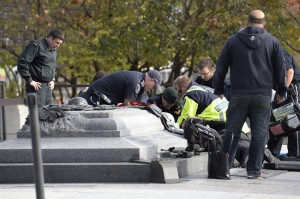A soldier, police and paramedics tend to a soldier shot at the National Memorial near Parliament Hill in Ottawa on Wednesday Oct.22, 2014. THE CANADIAN PRESS/Adrian Wyld 